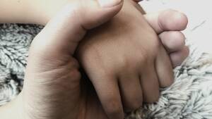 En stor hand som håller i en liten hand Grensman